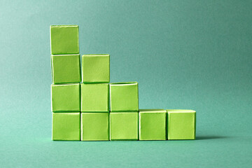 Ascending Stack of Green Cubes on a Soft Teal Background - Geometric Art