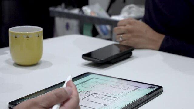 Engineer And Architect brainstorming architectural house plans and collaborate using tablet technology