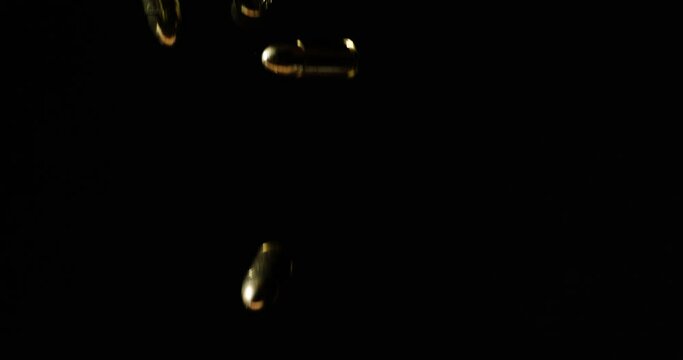 9mm Parabellum Bullets Falling Slowly Against Dark Background.