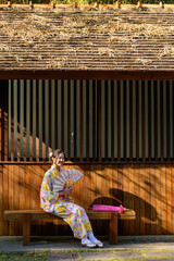 Young women wearing traditional Japanese kimono or yukata is happy and cheerful in the park.