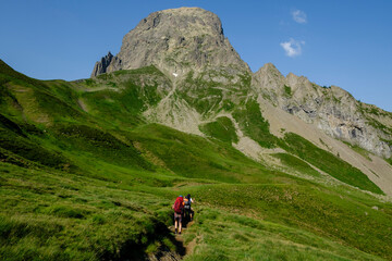 Fototapeta na wymiar hikers descending into the valley, Col de Souzon, Midi d'Ossau peak, 2884 meters, Pyrenees National Park, Pyrenees Atlantiques, France