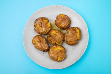 Tasty pieces of baked potatoes and salt and oil on plate