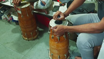 Musicians playing traditional drums closeup of hands and instruments cultural music concept man repairing drum at musical workshop