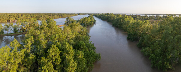 Aerial evening panoramic view of a side arm of the Ham Luong River in Vietnam's Mekong Delta, a...