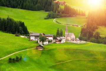 Mountain village in green valley in Dolomite alps in summer
