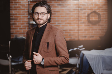 Concept status men client in barbershop. Portrait stylish man in jacket and glasses against...