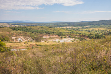 Old closed quarry. Puddles in an old quarry. Trees growing over geological structures of hercynian orogeny inside of old closed quarry in mountains in Ukraine