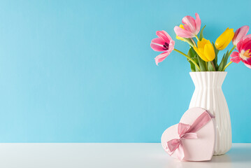 Commemorating Mother's Day and 8 March: A side view table scene with a heart-shaped package and fresh tulips, set against a calming blue background, with space for text insertion