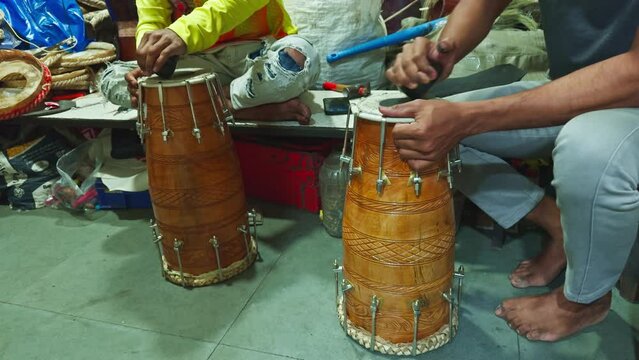 Traditional drum crafting hands working on percussion instruments with tools on table man repairing drum at musical workshop