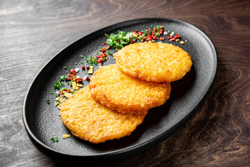 Hash Brown Garnish served on Black Dish. Potato Pancakes