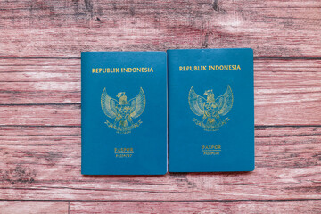 Top view of Indonesian passport on wooden table. Two green Indonesian passports on the table, identity documents for traveling abroad