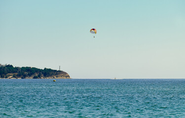Couple is parasailing in the blue sky. Summer vacation on the Black Sea.