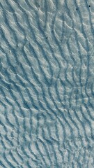 blue rippling sea, top view. water texture with visible dunes of sand