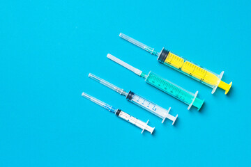 Top view of different syringes at blue background. Medical injection concept with copy space