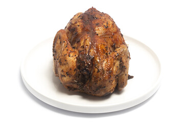 A whole delicious roasted chicken seasoned with herbs in a white plate isolated on white background clipping path