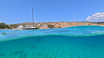 Underwater split photo of paradise crystal clear sea beach of Agios Georgios in main port of...