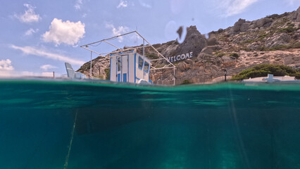 Underwater split photo of traditional fishing wooden boats in port of Iraklia island, small Cyclades, Greece