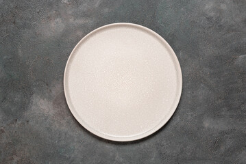 Empty beige plate on a dark grunge background. Top view, flat lay, copy space. - 748629519