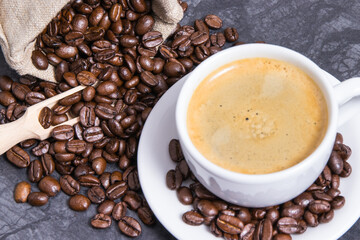 Coffee in white cup and roasted dark coffee beans