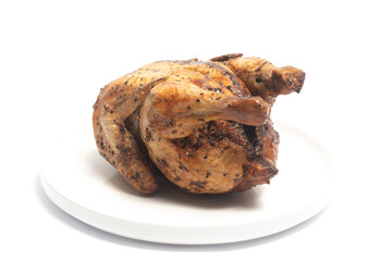 A whole delicious roasted chicken seasoned with herbs in a white plate isolated on white background clipping path