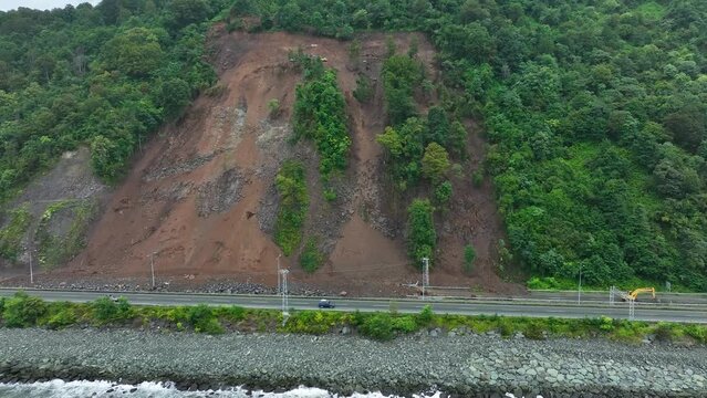 Mountain soil collapse in half of the highway. Landslides due to heavy rainfall. Rockslide over road. Dangerous Landslide, natural disaster led to roadblock. Climate change, warming, desertification