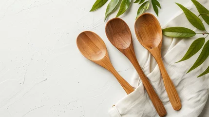Deurstickers Handcrafted bamboo spoon set on a plain white background, blending natural beauty with functional design. © Ahmad