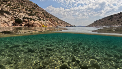 Underwater split photo of paradise fjord rocky bay of Tourkopigado, Iraklia island, small Cyclades, Greece
