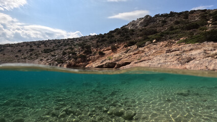 Fototapeta na wymiar Underwater split photo of paradise fjord rocky bay of Tourkopigado, Iraklia island, small Cyclades, Greece
