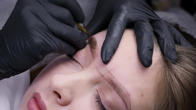 The process of work of a master of permanent makeup who performs eyebrow tattooing. Permanent makeup procedure, performing PMU of eyebrows