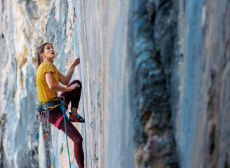 The girl climbs the rock. The climber trains on natural terrain. Extreme sport.  A woman overcomes...