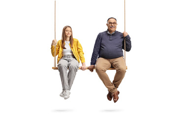 Grandfather and teenage girl sitting on a big wooden swing