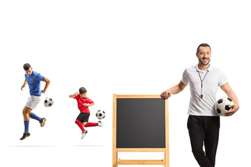Fototapeta premium Football players at training and coach leaning on a blackboard
