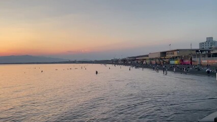 FUJISAWA, KANAGAWA, JAPAN - AUGUST 2023 : View of Enoshima beach (sea) at Shonan area in sunset. Romantic, moody sky in dusk. Japanese hot summer holiday (vacation) season concept video.
