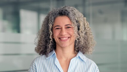 Happy middle aged professional business woman standing in office, portrait. Smiling mature senior female corporate leader, confident lady executive manager looking at camera, close up.