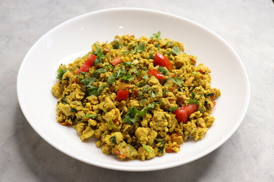Anda Masala Bhurji or Spicy Indian scrambled eggs with bread or Bun Pav, a popular street food in Mumbai. Served in a white plate along with copy space. egg bhurji or parasi akuri. with jowar bhakri.