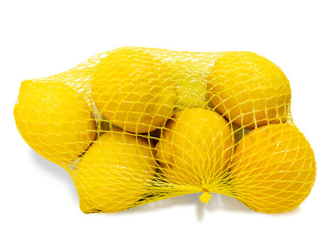 Lemons in yellow plastic net isolated on white with clipping path. Yellow lemons packaged for sale