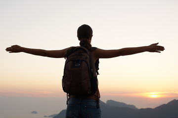 Woman, silhouette and freedom with mountain, sunset and adventure for travel or holiday. Tourist,...