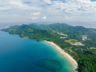 Sandy beach with inshore waves. Dagmay Beach. Blue sky and clouds. El Nido, Philippines.