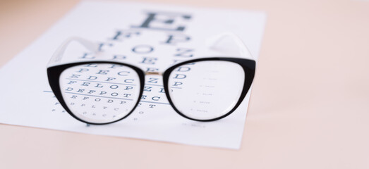 Black frame vision glasses on Snellen chart.