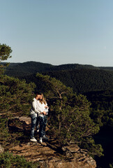 happy young pregnant couple in the mountains. husband and pregnant wife in nature. happy relationship concept