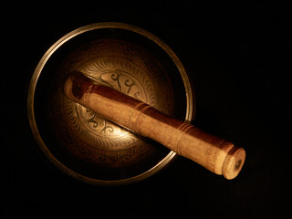 Fototapeta premium A cenital view of a Tibetan singing bowl in a black background 