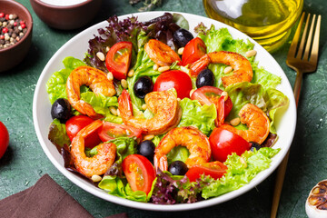 Salad with shrimps, tomatoes, olives and nuts. Healthy eating.