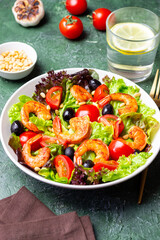 Salad with shrimps, tomatoes, olives and nuts. Healthy eating.