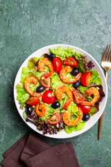 Salad with shrimps, tomatoes, olives and nuts. Healthy eating.