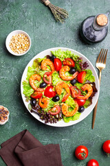 Salad with shrimps, tomatoes, olives and nuts. Healthy eating.