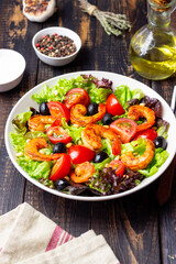 Salad with shrimps, tomatoes, olives and nuts. Healthy eating.