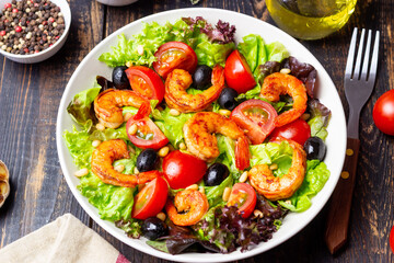 Salad with shrimps, tomatoes, olives and nuts. Healthy eating.