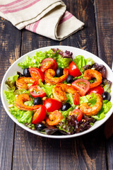 Salad with shrimps, tomatoes, olives and nuts. Healthy eating.