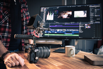 Photographe vidéaste devant un ordinateur en train de faire du montage et de la post-production dans un studio créatif - 748652907