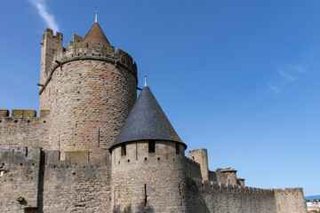 Fototapeta na wymiar Low angle view of fortified wall with battlement and towers of the city of Carcassonne, a medieval fortress from Gallo-Roman period and part of UNESCO list of World Heritage Sites
